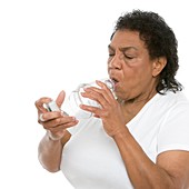 Woman using an asthma spacer