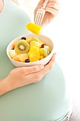Pregnant woman eating a fruit salad