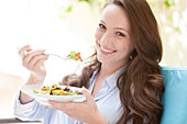 Young woman eating a salad