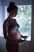 Pregnant woman using tablet computer