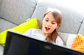 Girl using laptop with surprised face