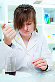 Young woman using a pipette in a lab