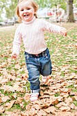 Young girl running in the leaves