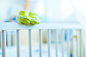 Baby shoes on the edge of a cot