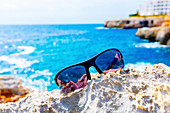 Sunglasses on the rocks by the sea