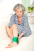 Woman with a cold compress on ankle