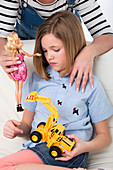 Girl with toy truck,mother holding doll