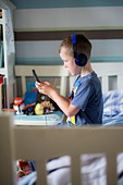 Boy wearing headphones using device