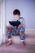 Boy sitting on a step using a tablet