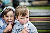 Two boys eating ice creams