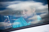 Girl using smartphone in car