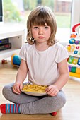 Girl sitting on floor with french fries