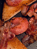 Close-up of fried bacon & bread in frying pan