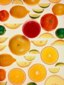 Slices of various citrus fruits and glass of juice