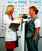 Obese woman being weighed at a weight clinic