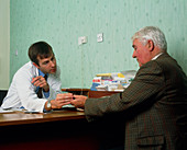 Man with Parkinson's disease consults his doctor