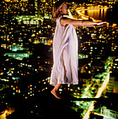 Abstract image of sleepwalking woman above a city