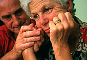Depressed elderly woman comforted by partner