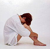 Depressed teenage girl with her head on her knees