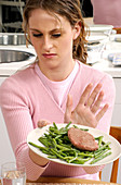 Woman rejecting a plate of food