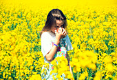 Young girl suffering from hay fever in a field