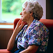 Loneliness: elderly woman stares out of window