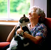 Loneliness: elderly woman getting comfort from cat