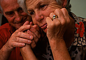 Depressed elderly woman comforted by elderly man