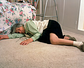 Elderly woman lying on floor after a fall