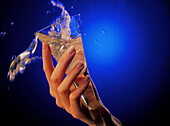 Woman's hand spills glass of alcoholic drink