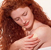 Woman sticks a nicotine patch onto her arm