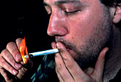 Drug user lights a marijuana cigarette (joint)