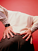 An elderly man experiencing lower back pain