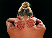 Neck/shoulder pain:hands of woman held behind neck