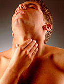 Man holds his neck suffering neck or throat pain
