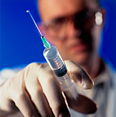 Doctor gently squeezing a syringe
