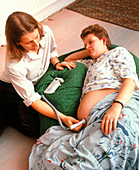Midwife checking foetus with doppler ultrasound