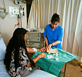 Nurse helps patient on kidney dialysis machine