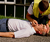 Ambulanceman checks patient's breathing