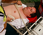 Ambulanceman using portable defibrillator machine