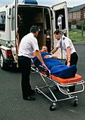 Ambulancemen loading patient into ambulance