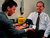 GP measures blood pressure with analogue sphygmo