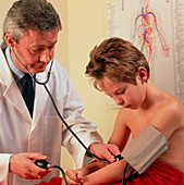 Doctor takes the blood pressure of a young boy