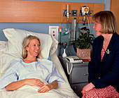 Woman visiting patient in private hospital room