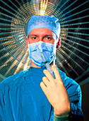 Anaesthetist in surgical dress holds a syringe