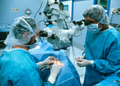 Surgeons using microscope to carry out eye surgery