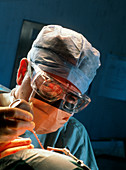 Surgeon conducting cochlear implant ear surgery