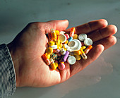 Hand holding assorted pills,tablets & capsules