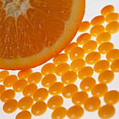 View of vitamin C pills and an orange half