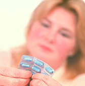 Obese woman holds Xenical weight-loss drug